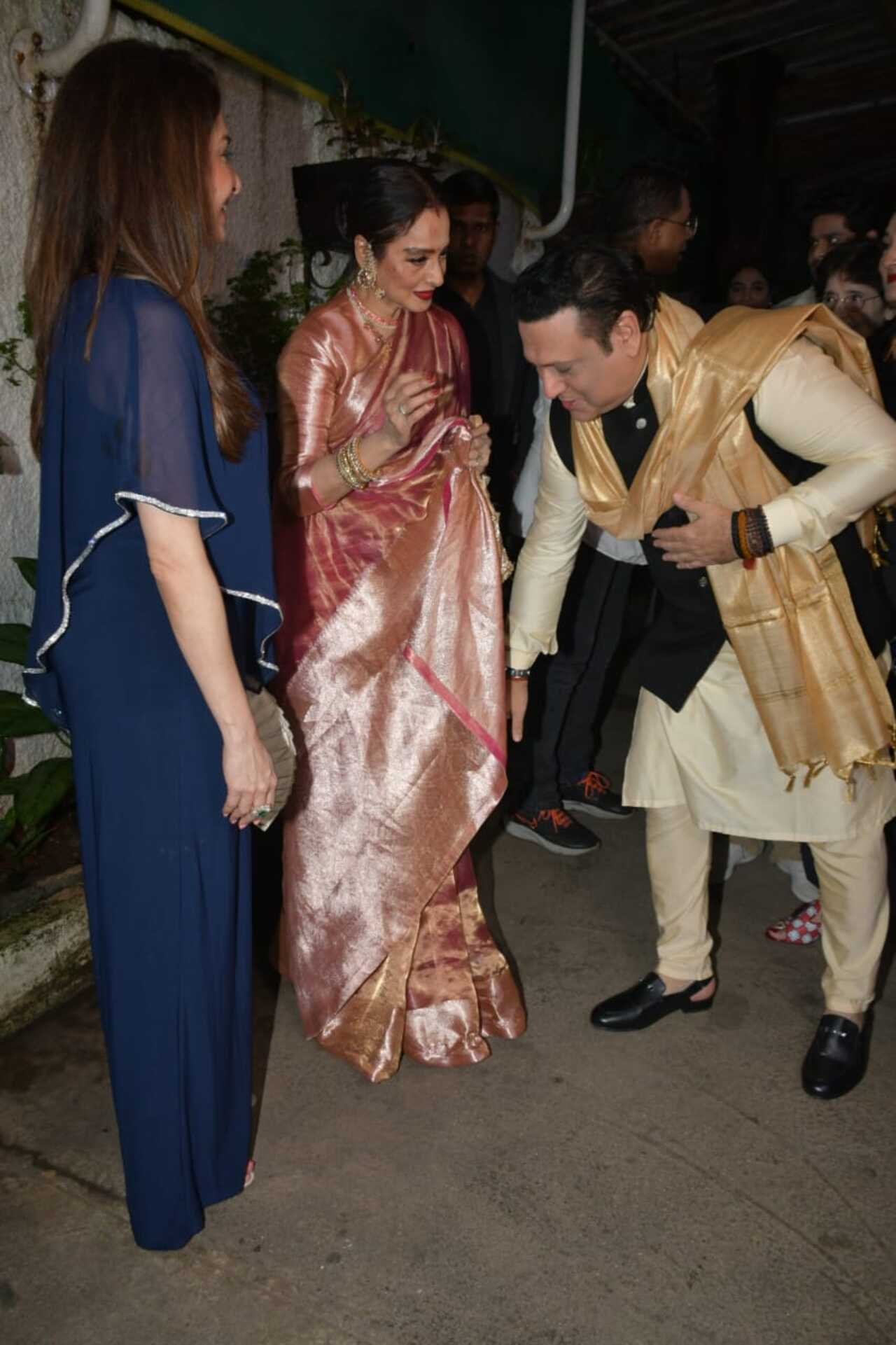 Govinda touches Rekha's feet while greeting her at the screening